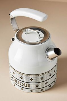 a white tea kettle sitting on top of a table