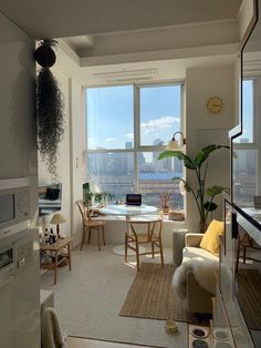 a living room filled with furniture and a large window overlooking a cityscape in the distance