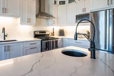 a kitchen with marble counter tops and stainless steel appliance in the center island