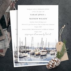 an image of a wedding card with sailboats in the water and pine cones on top