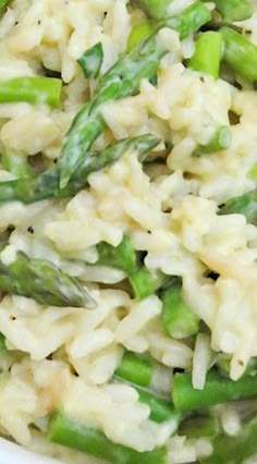 a white bowl filled with rice and asparagus