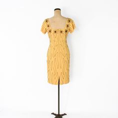 "~ 1950s exquisite golden yellow crepe beaded cocktail dress ~ Wonderful wiggle dress ~ Extensive bronze beading throughout ~ Square neckline front & back with beaded flowers ~ Gold satin lining ~ 14.5\" (37 cm) back metal zipper ~ Excellent Label: Original Mr. Frank, New York Bust- 34\" (86.5 cm) Waist- 28\" (71 cm) Hips- 36\" (91.5 cm) Length- 39\" (99 cm) Shoulders- 16\" (41 cm) Sleeve- 5\" (12.5 cm) More Incredible Vintage: glennasvintageshop.etsy.com Vintage Jewelry: glennasjewels.etsy. Fitted Yellow Embellished Dress, Yellow Embellished Fitted Dress, Gold Fitted Retro Dress, Fitted Yellow 1950s Dresses, Fitted Embellished Dress For Vintage Events, Fitted Gold Retro Dress, Fitted Mid-century Yellow Dress, Mid-century Yellow Fitted Dress, Vintage Beaded Dress For Vintage Events