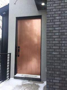 a brown door is in front of a brick building