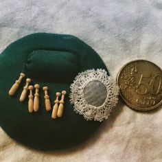 a green hat with wooden pins on it and a small coin sitting next to it