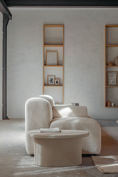 a living room with a white couch and coffee table in the middle, surrounded by bookshelves