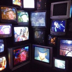 a room filled with lots of different types of tvs on wall next to each other