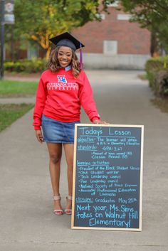 a woman in a graduation cap and gown holding a sign