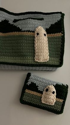 two crocheted bags with ghost faces on them, one is green and the other is gray