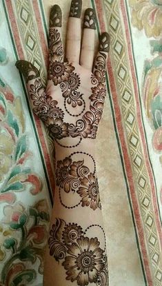 a woman's hand with henna tattoos on it