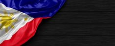 the flag of philippines on a black wooden background with space for your text or image