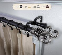 the curtain rod is attached to the side of a door with two black handles and one white handle