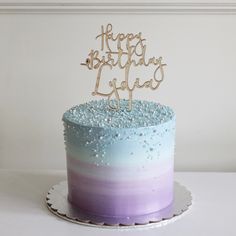 a blue and purple ombrella birthday cake with a happy birthday sign on top