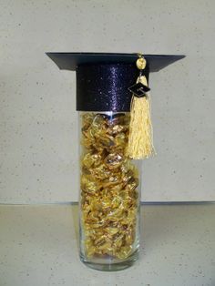 a graduation cap and tassel in a jar filled with gold confetti coins