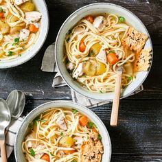 three bowls of chicken noodle soup with spoons