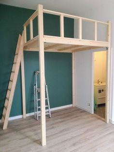 a loft bed is being built in a room with green walls and white trimmings