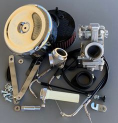 an assortment of carburets and parts on a gray background with clipping