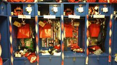 the locker room is filled with red and blue football jerseys, hats, and gloves