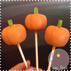 three orange pumpkin shaped lollipops on a stick