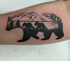 a bear and cub tattoo on the left arm, with mountains in the back ground