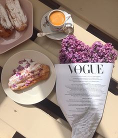 a table topped with pastries and flowers next to a cup of coffee