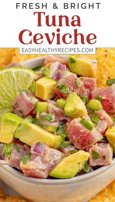 a bowl filled with tuna and avocado next to tortilla chips