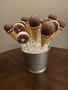 ice cream cones with sprinkles and chocolate covered pretzels in a bucket