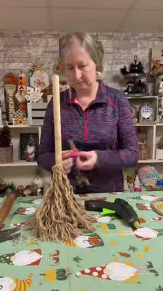 a woman is cleaning the table with a broom