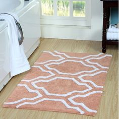 a bathroom rug with an orange and white pattern