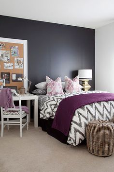 a bedroom decorated in purple and white with pictures on the wall