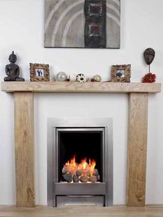 a fire place in a living room next to a wall with pictures on the mantle