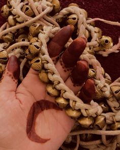 a person's hand is covered in gold and brown beads