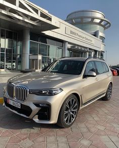 a silver bmw suv parked in front of a building