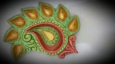 a decorative wall hanging made out of green and gold leaves