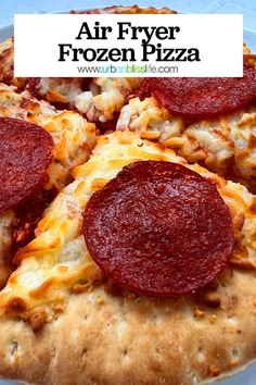 a pizza with pepperoni and cheese sitting on top of a white plate next to the words air fryer frozen pizza