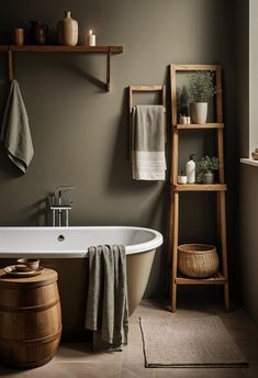 a bath tub sitting next to a wooden shelf filled with towels and other bathroom items