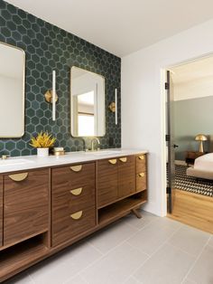 a bedroom with two mirrors and a bed in the background, along with a large wooden dresser