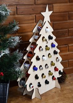 a wooden christmas tree with wine bottles on it and a potted plant next to it