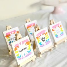 four easels with colorful paint splattered on them sitting on a white sheet