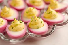 small deviled eggs are arranged on a glass plate