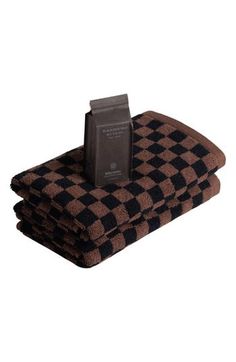 two brown and black checkered towels with a chocolate bar in the middle on top