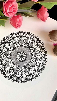 a drawing on paper with pink flowers in the background and a pen next to it