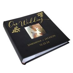 a black wedding album with gold lettering and a photo on the cover is shown in front of a white background