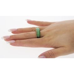 a woman's hand with a green ring on it