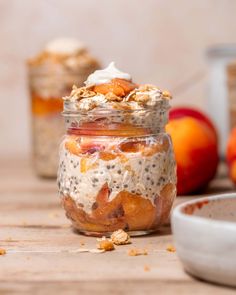 two jars filled with oatmeal and fruit on top of a wooden table