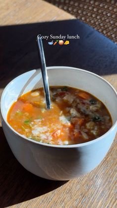 a white bowl filled with soup on top of a wooden table