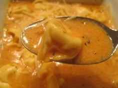 a spoon full of soup with noodles and cheese