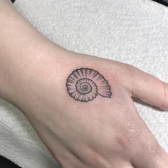 a person's hand with a small tattoo on it