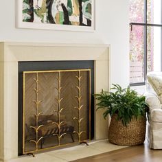 a living room with a fire place and potted plants on the floor next to it