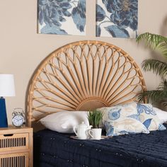 a bamboo headboard on a bed in a room with blue and white pillows, two paintings above it