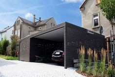 a car is parked in a garage on the side of a road near some houses